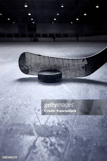 hockey stick and puck - ice hockey stockfoto's en -beelden