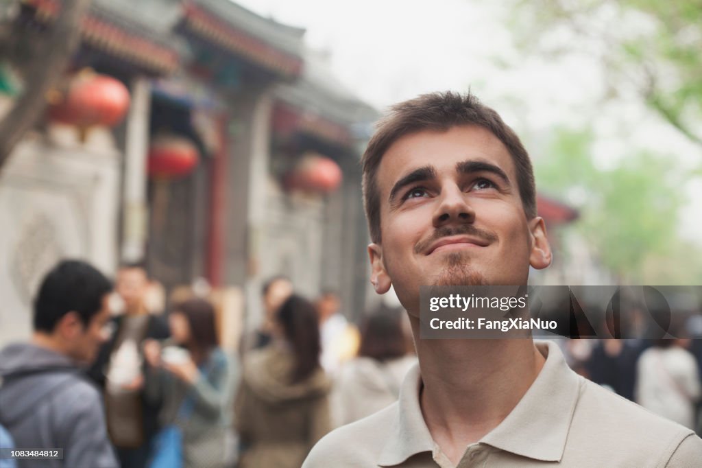 Smiling mixed race man looking up outdoors