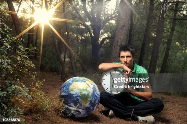 homme tenant une horloge près de la terre de - top of the world photos et images de collection