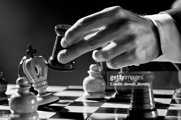 schach strategie, schach-spieler, der geschäftsmann der schachbrett bewegen, schwarz-weiß - schach matt stock-fotos und bilder