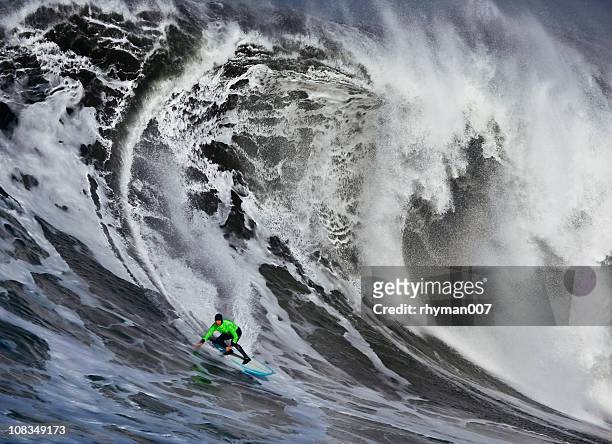 surfing a huge wave - big wave surfing stock pictures, royalty-free photos & images