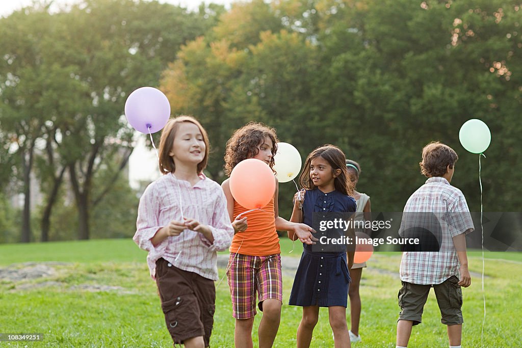 Children at birthday party holding balloons