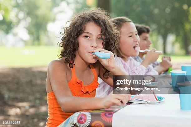 girl at birthday party with party blower - picnic table park stock pictures, royalty-free photos & images