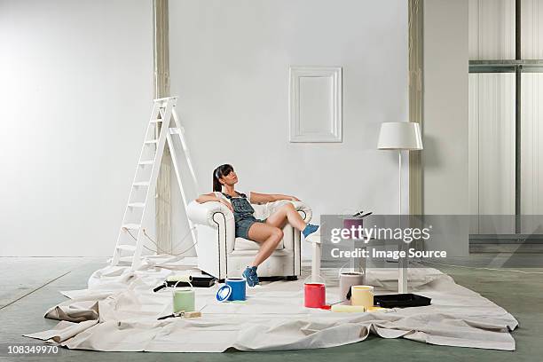 young woman in armchair with decorating equipment - step stool stock pictures, royalty-free photos & images