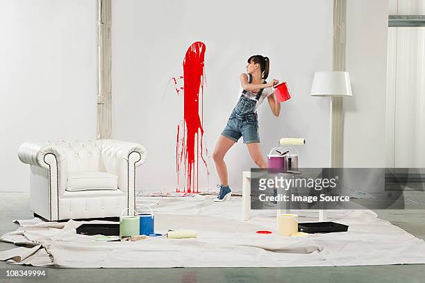 giovane donna spruzzi vernice rossa sul muro bianco - destruction foto e immagini stock