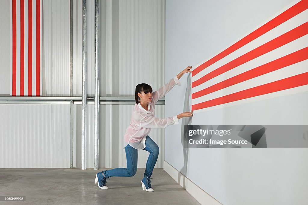 Young woman with striped wallpaper