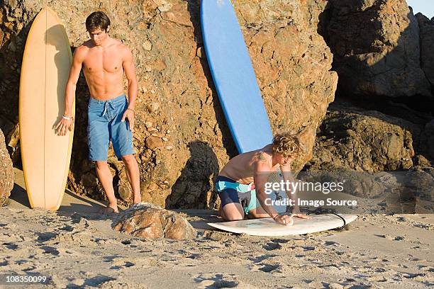 surfers at the beach - board shorts stock pictures, royalty-free photos & images