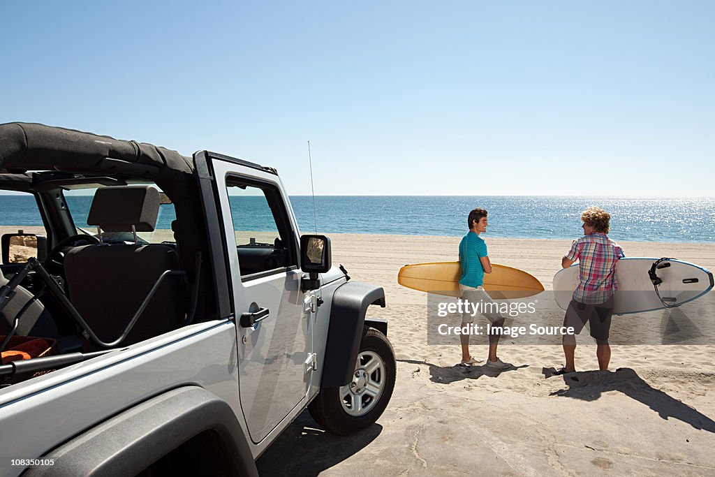 Two young men at the beach with surfboards