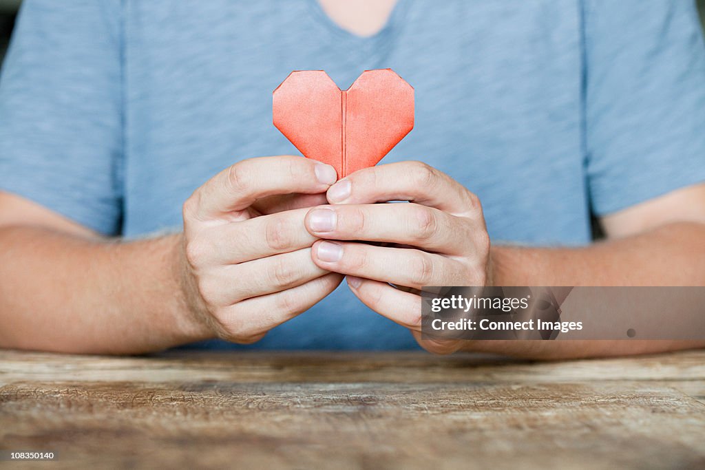 Person holding origami heart