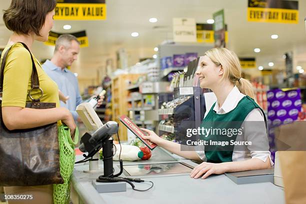 cashier and customers at supermarket checkout - shop till stockfoto's en -beelden