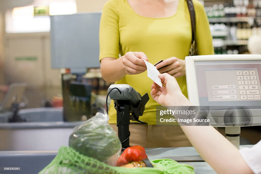 Cashier handing receipt to customer