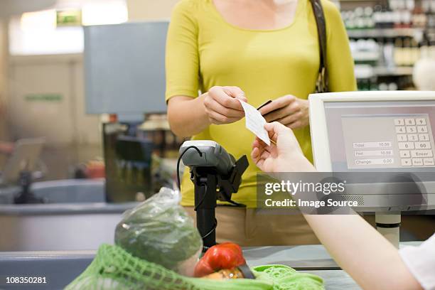 cashier handing receipt to customer - receipt stock pictures, royalty-free photos & images