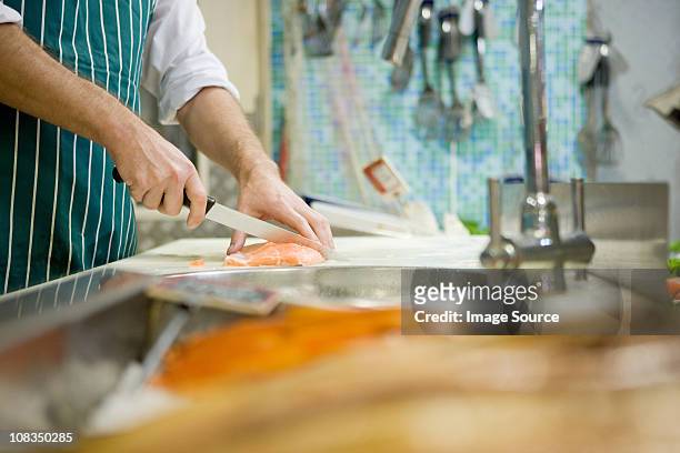 primo piano di taglio fishmonger pesce - pescivendolo foto e immagini stock