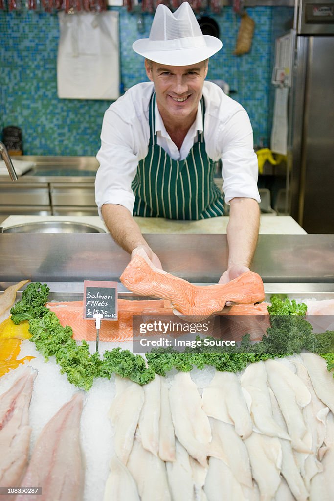 Fishmonger holding fillet of salmon