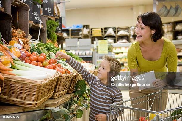 mother and son in supermarket - shoppers ahead of consumer price index stockfoto's en -beelden