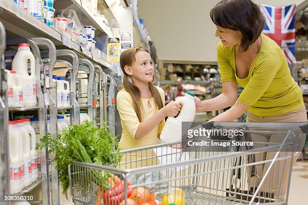 mère et fille se lait dans un supermarché - mom buying milk photos et images de collection