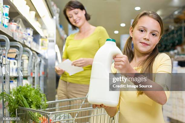 mother and daughter getting milk in supermarket - milk family stockfoto's en -beelden