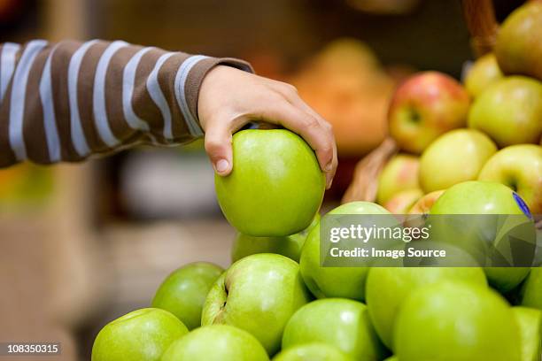 kind hält einen apfel - supermarket fruit stock-fotos und bilder