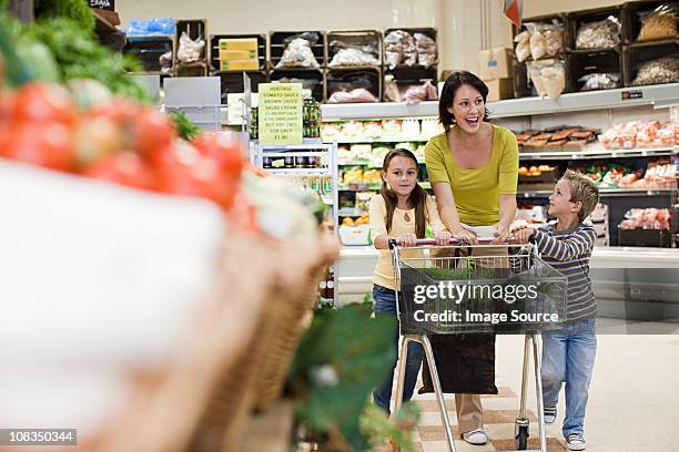 mother and children in supermarket - family with two children british stock pictures, royalty-free photos & images