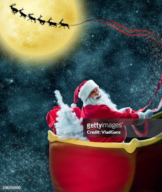 santa claus in his deer sled near the moon - magie de noel stockfoto's en -beelden