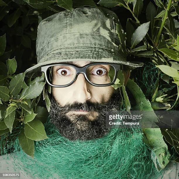 scared to death by a lizard, nerd with green hat. - camouflagekleding stockfoto's en -beelden