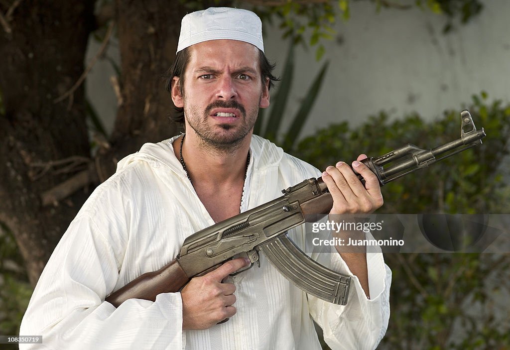 Middle Eastern Man Dressed in White and Armed with Gun