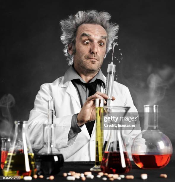 mad scientist playing with syringe - mad professor stock pictures, royalty-free photos & images