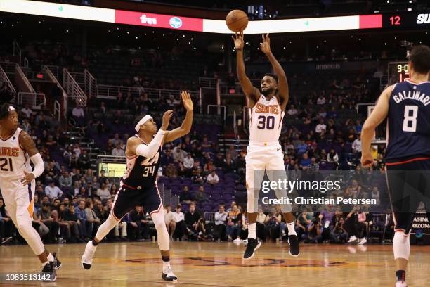 Troy Daniels of the Phoenix Suns shoots over Tobias Harris of the LA Clippers during the NBA game at Talking Stick Resort Arena on December 10, 2018...