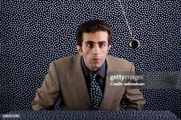 man in oldfashioned suit mesmerized by looking at pocket watch - hypnotherapy stock pictures, royalty-free photos & images