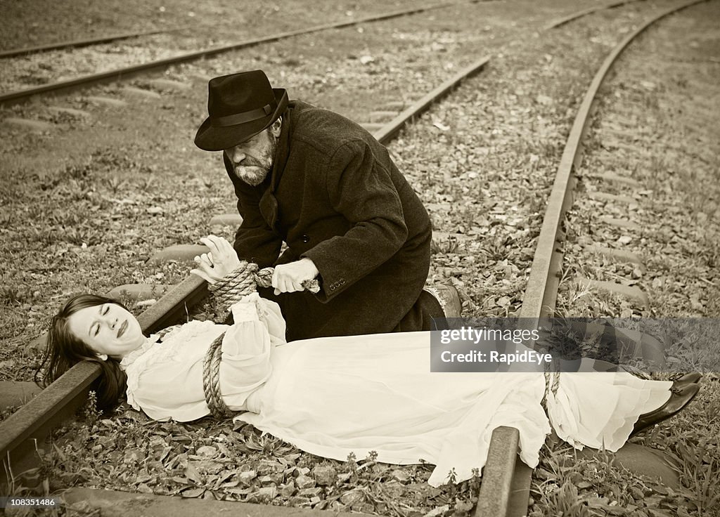 Victorian figura de vilão tying maiden para railroad