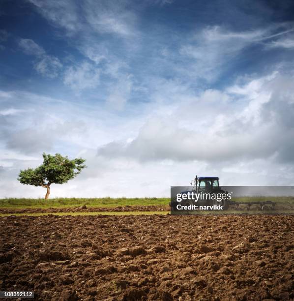 tractor ploughing on the field - tractor in field stockfoto's en -beelden