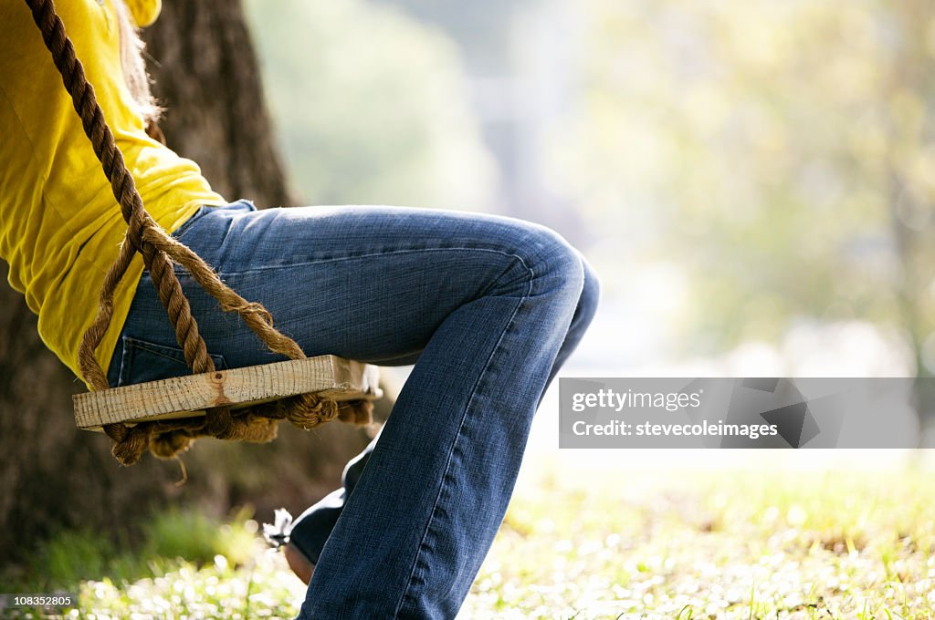 Woman Sitting on a Park Swing