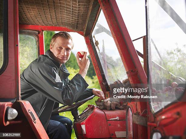 farmer in tractor eating apple - agriculteur conducteur tracteur photos et images de collection