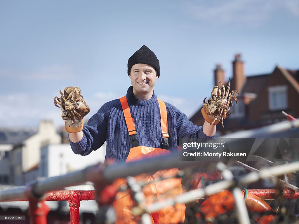 Fisherman holding crabs on boat