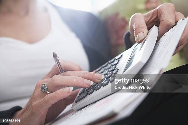 close-up of woman's hands on calculator - budget uk stock-fotos und bilder