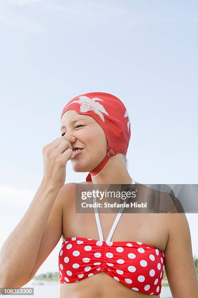 girl holding breath - pinching nose stockfoto's en -beelden