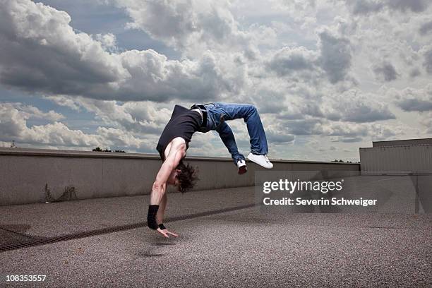 young man jumping backwards - salto de espalda fotografías e imágenes de stock