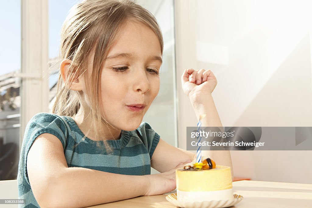 Girl blowing out candle on birthday cake