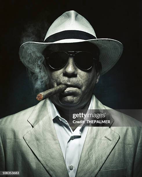 elegant cuban mysterious man smoking a cigar - organiserad brottslighet bildbanksfoton och bilder