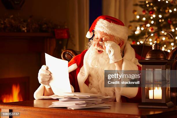 jolly father christmas reading letters from children - christmas elderly stock pictures, royalty-free photos & images