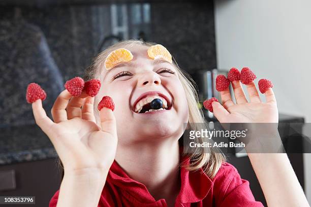 girl playing with fruit - child eating a fruit stock-fotos und bilder