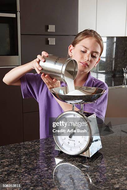 girl weighing sugar on kitchen scales - sugar canister stock pictures, royalty-free photos & images