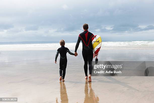 father and son going surfing - father and son walking stock pictures, royalty-free photos & images