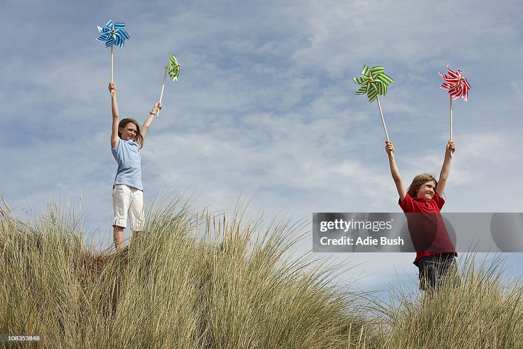 Girls holding windmills up in the sky