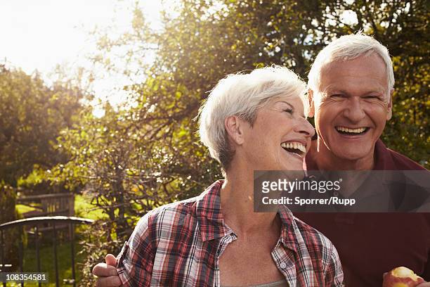 senior couple in front of lake - baby boomer stock pictures, royalty-free photos & images