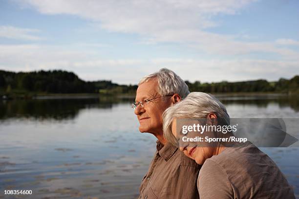 senior woman lying head on mans shoulder - senior woman portrait stock-fotos und bilder