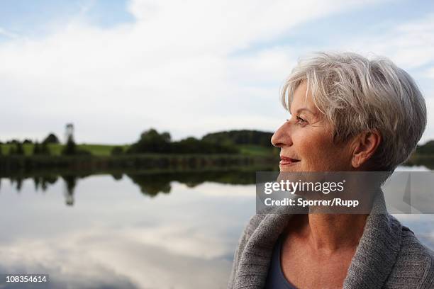 senior woman watching sunset - active seniors stock pictures, royalty-free photos & images