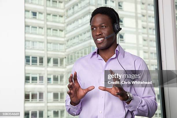 businessman talking on telephone headset - bluetooth stock pictures, royalty-free photos & images