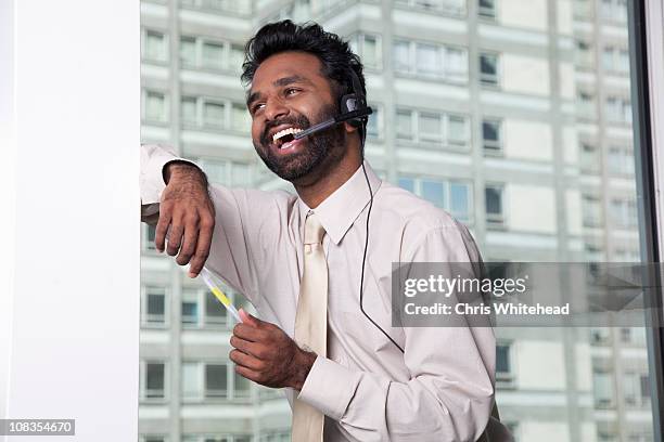 businessman using telephone headset - bluetooth stock pictures, royalty-free photos & images