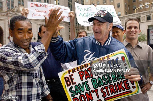 Hector Bodre of Washington Heights celebrates with Freddy Schuman of the Bronx, who claims to be the Yankee fan, outside of the baseball strike talks...